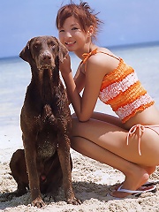 Cute asian girl having fun at the beach in her pink bikini
